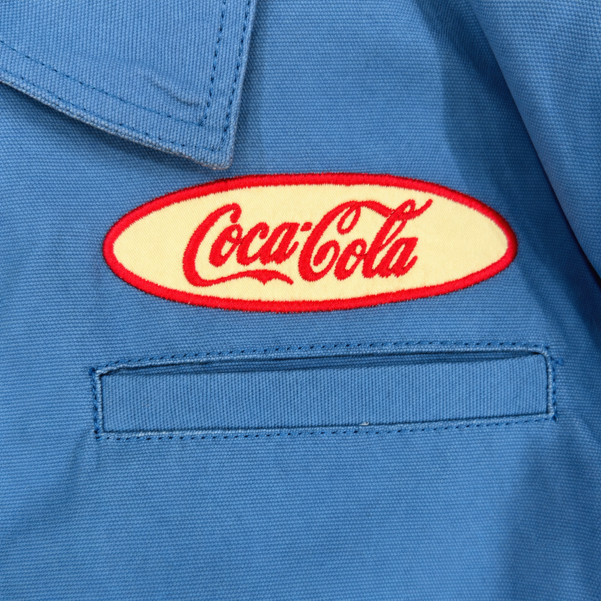 PREME blue Coca-Cola jacket oval chest patch and pocket close-up